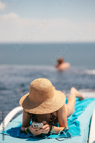 Young beautiful woman in swimsuit sunbathes on a sun lounger