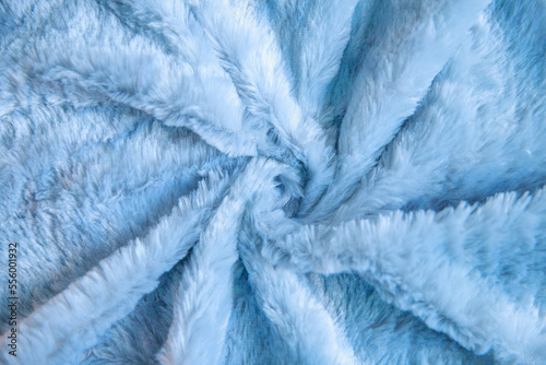 Fluffy fabric twisted in the center, soft fluff on the carpet, woolen bedspread. 