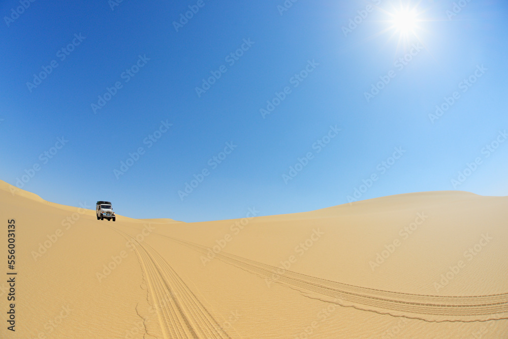 Four Wheel Drive Car in Desert with Blue Sky and Sun, Matruh, Great Sand Sea, Libyan Desert, Sahara Desert, Egypt, North Africa, Africa Four Wheel Drive Car in Desert with Blue Sky and Sun, Matruh, Great Sand Sea, Libyan Desert, Sahara Desert, Egypt, North Africa, Africa