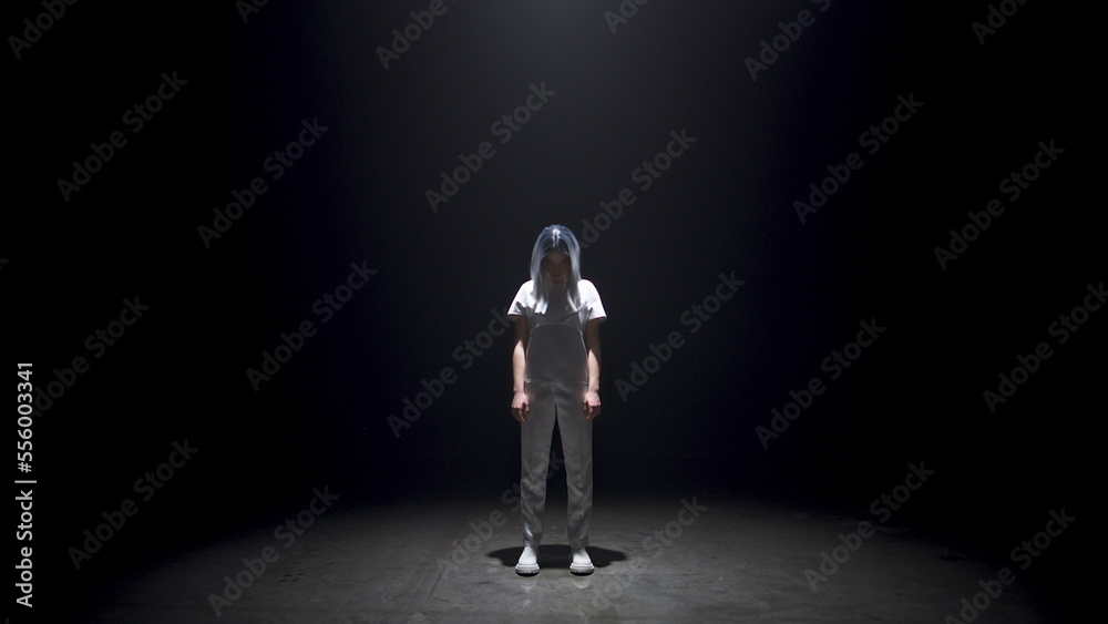 Fototapeta premium Fashionable girl posing dark background. Futuristic metaverse model in light.