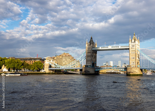 Famous London bridge over the river Thames the Tower Bridge in broad daylight, sunlit under the cloudy sky, side view.