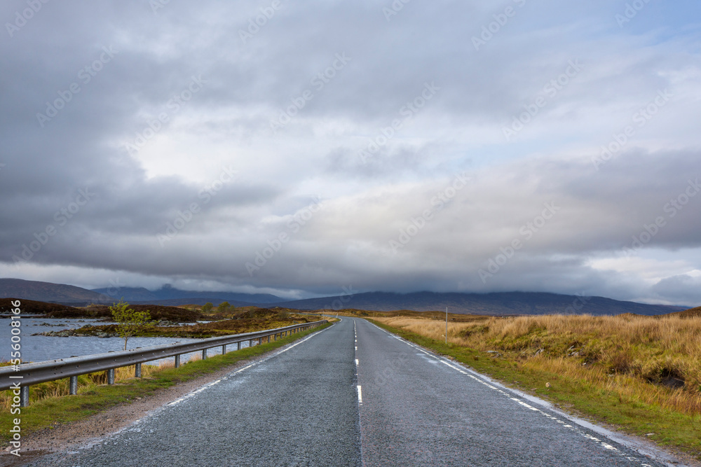 Country road through moor landscape with dense cloudy sky at Rannoch Moor in Scotland, United Kingdom Country road through moor landscape with dense cloudy sky at Rannoch Moor in Scotland, United Kingdom