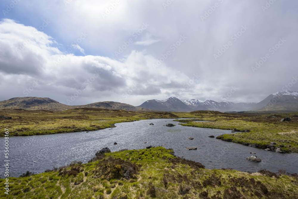 Moor landscape with a river and the sun shining through the cloudy sky at Rannoch Moor in Scotland, United Kingdom Moor landscape with a river and the sun shining through the cloudy sky at Rannoch Moor in Scotland, United Kingdom