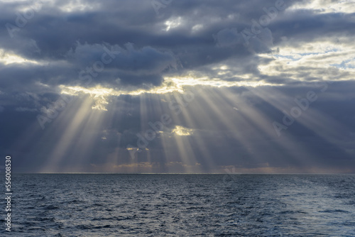 Crepuscular sunrays shining through the clouds over the North Sea, United Kingdom