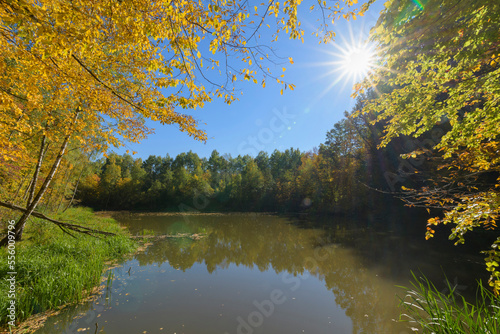 Pond with colorful autumn leaves and bright sun, Rothenbuch, Hafenlohrtal, Spessart, Bavaria, Germany photo