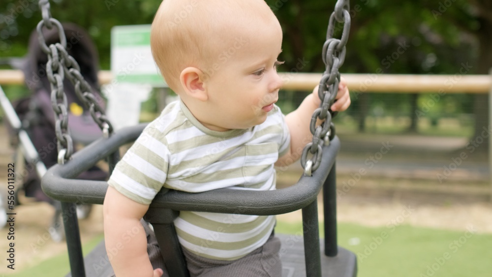 Funny Little Younger Newborn Infant Brother Boy On Swing. Baby Playing On Playground. Summer time outside. Kids Entertainment, Childhood, Child Development, Happy Family Concept Funny Little Younger Newborn Infant Brother Boy On Swing. Baby Playing On Playground. Summer time outside. Kids Entertainment, Childhood, Child Development, Happy Family Concept