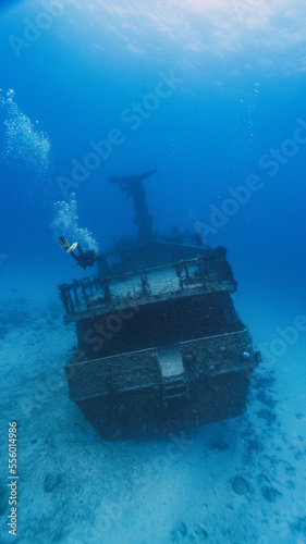 scuba diver swimming into a deep wreck