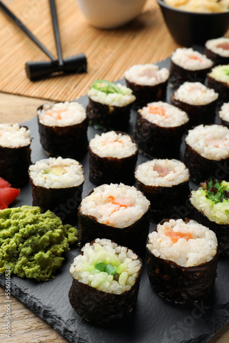 Tasty sushi rolls served on wooden table