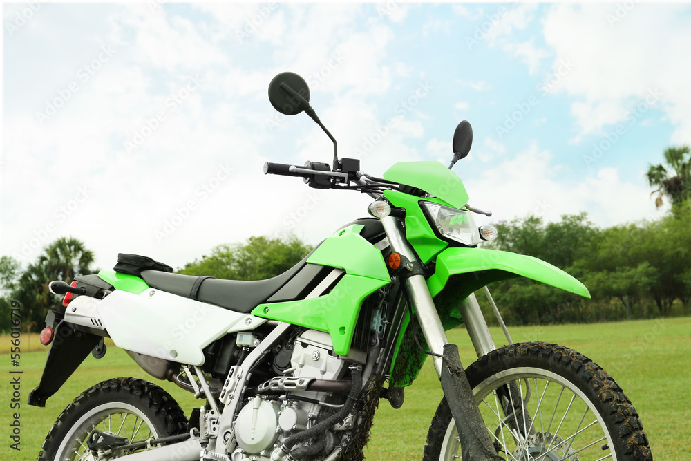 Green stylish cross motorcycle on grass outdoors Green stylish cross motorcycle on grass outdoors