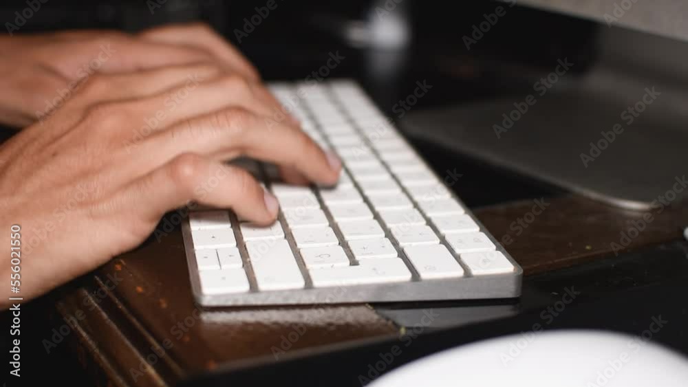 Manos de un hombre joven delgado typeando o tecleando en un teclado de computadora investigando o escribendo en el teclado 