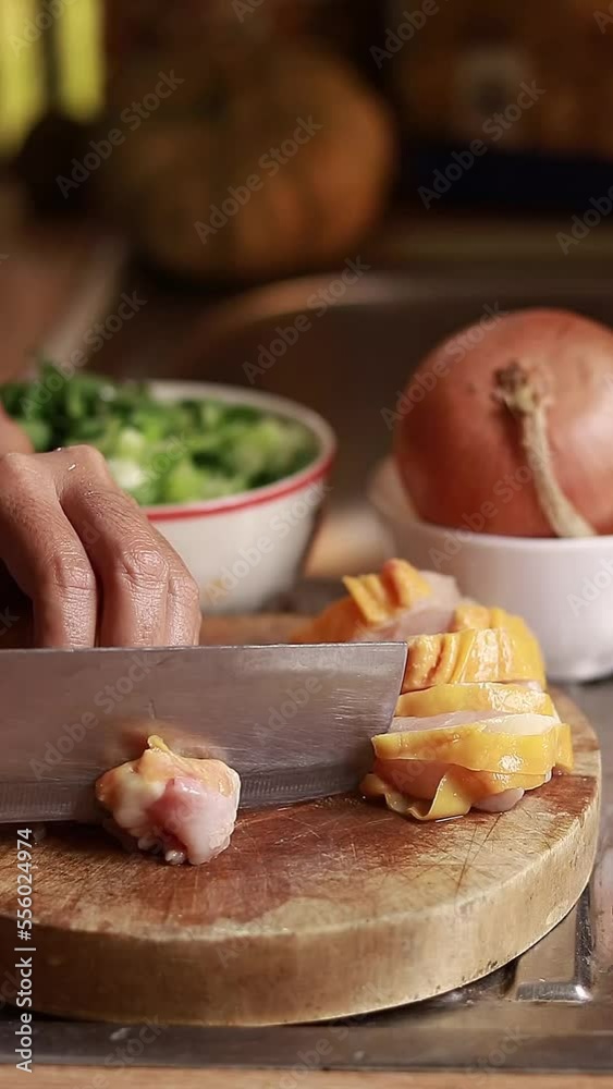 Vertical video close up to hands slicing raw chicken breast in preparation for a meal for Christmas dinner Vertical video close up to hands slicing raw chicken breast in preparation for a meal for Christmas dinner