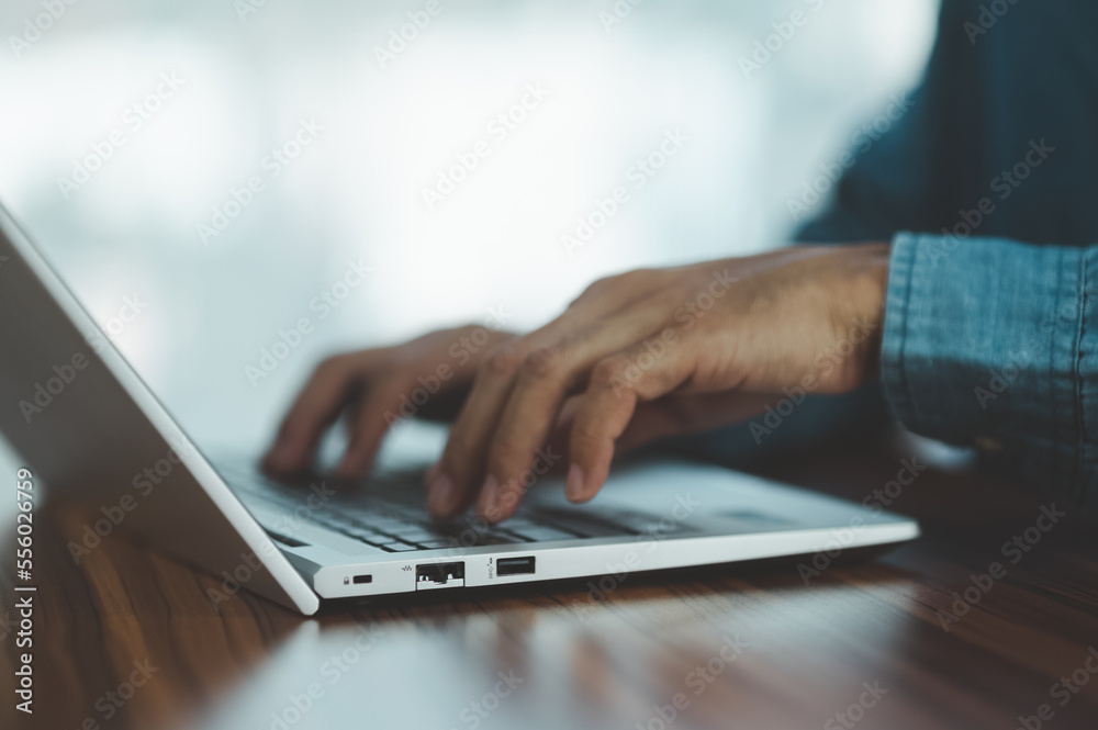 People using computer Side view of male hands typing on laptop keyboard People using computer Side view of male hands typing on laptop keyboard