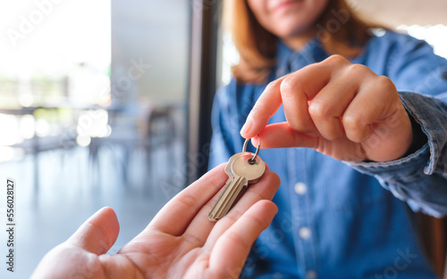 Closeup image of a real estate agent giving the keys to owner or buyer