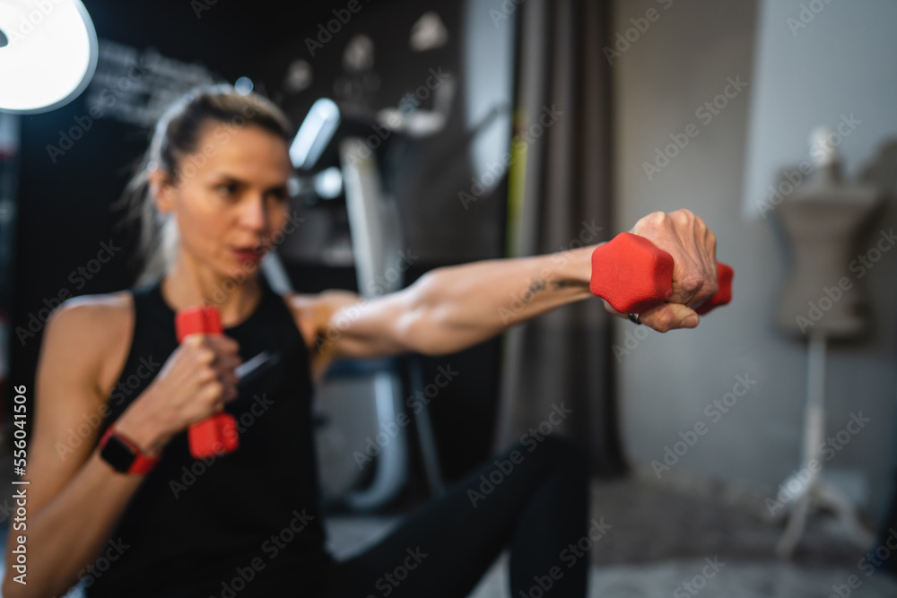 Fototapeta premium mature caucasian woman slim female use dumbbell weights for training