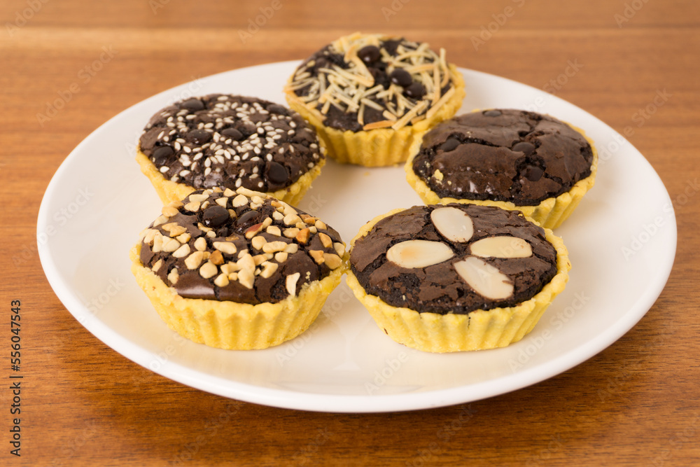 Mini tart with brownie filling. Crispy on the outside, soft on the inside, combined with various toppings such as peanuts, choco chips, cheese and almonds. Perfect for serving with coffee and tea