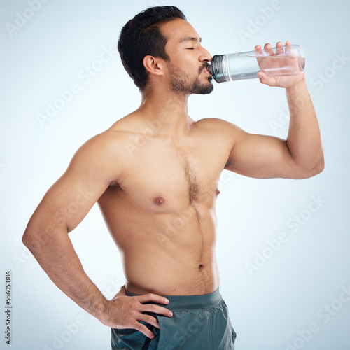 Fitness, health or man drinking water in studio after training in workout or exercise for body goals or wellness. Motivation, weight loss or tired healthy person relaxing and drinks liquid or bottle