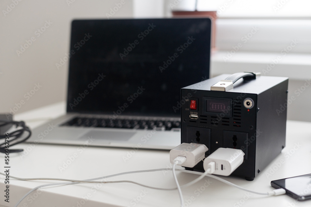 Obraz premium Charging station for phone, tablet, laptop and other gadgets when there is no light during blackout. Generator power bank battery in the absence of electricity. Charge electric rechargeable battery