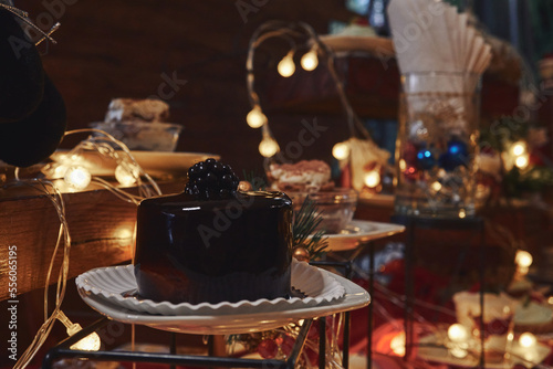 Pastel de chocolate con fondo de adornos navideños, luces cálidas y postres variados © Angel Trejo