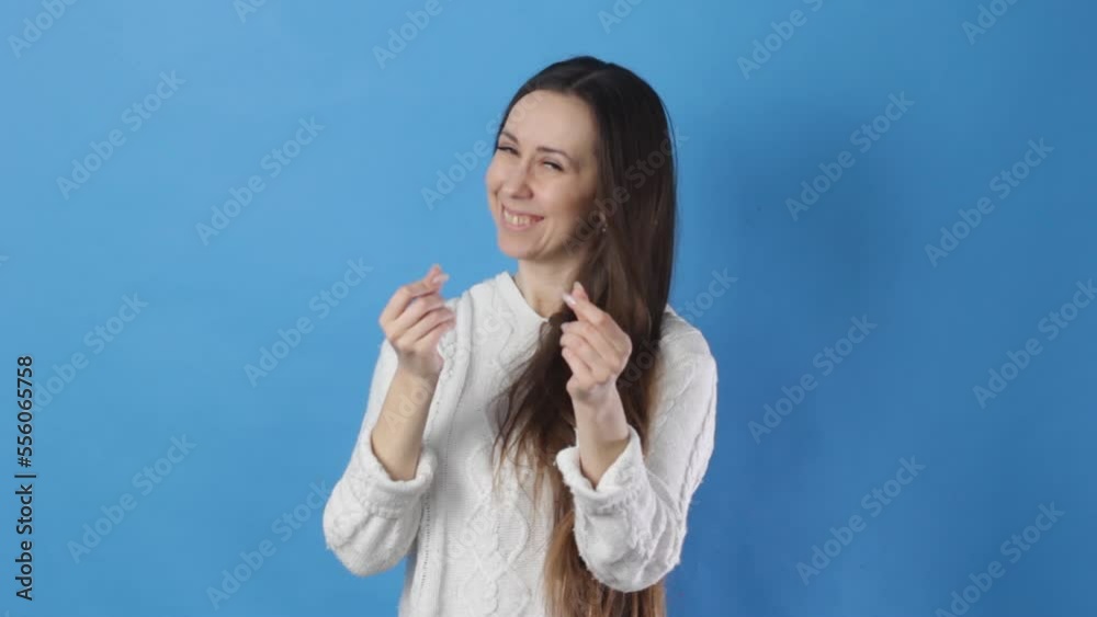 A cunning smart woman demonstrating a monetary gesture imitating the scattering of cash, body language. a closed studio shot isolated on a blue background A cunning smart woman demonstrating a monetary gesture imitating the scattering of cash, body language. a closed studio shot isolated on a blue background