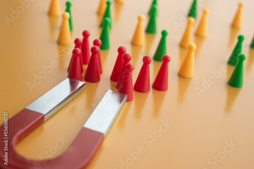 Horseshoe magnet attract red people from crowd on yellow background. Attracting target customer in marketing business and human resources (hr) recruitment best person concept. Right man on right job.