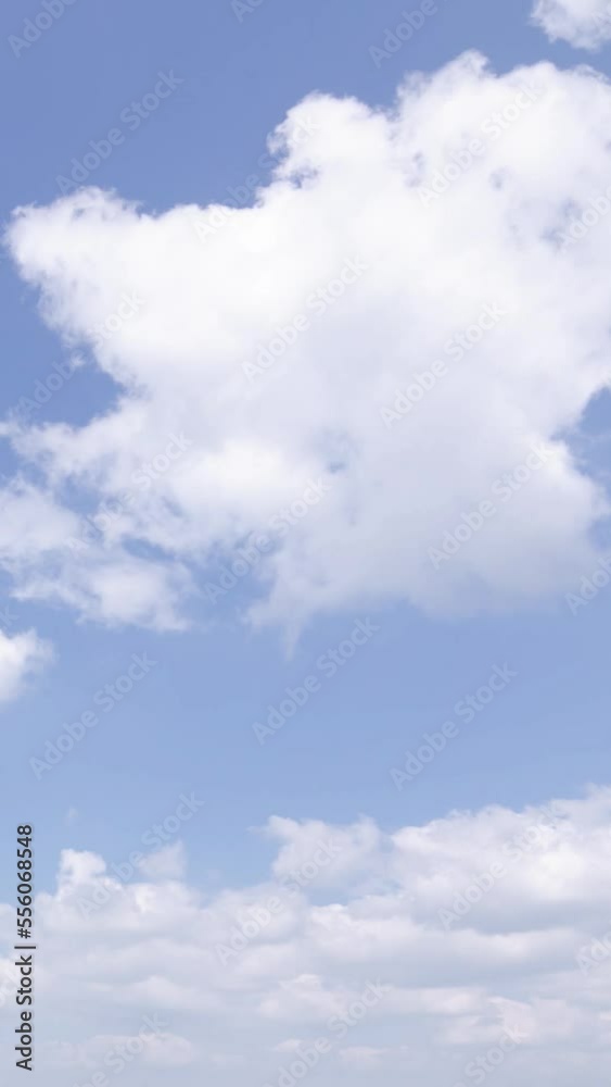 vertical timelapse view of Blue sky white puffy fluffy white clouds. Cumulus cloud cloudscape Summer blue sky time lapse. Nature weather blue sky. vertical timelapse view of Blue sky white puffy fluffy white clouds. Cumulus cloud cloudscape Summer blue sky time lapse. Nature weather blue sky.