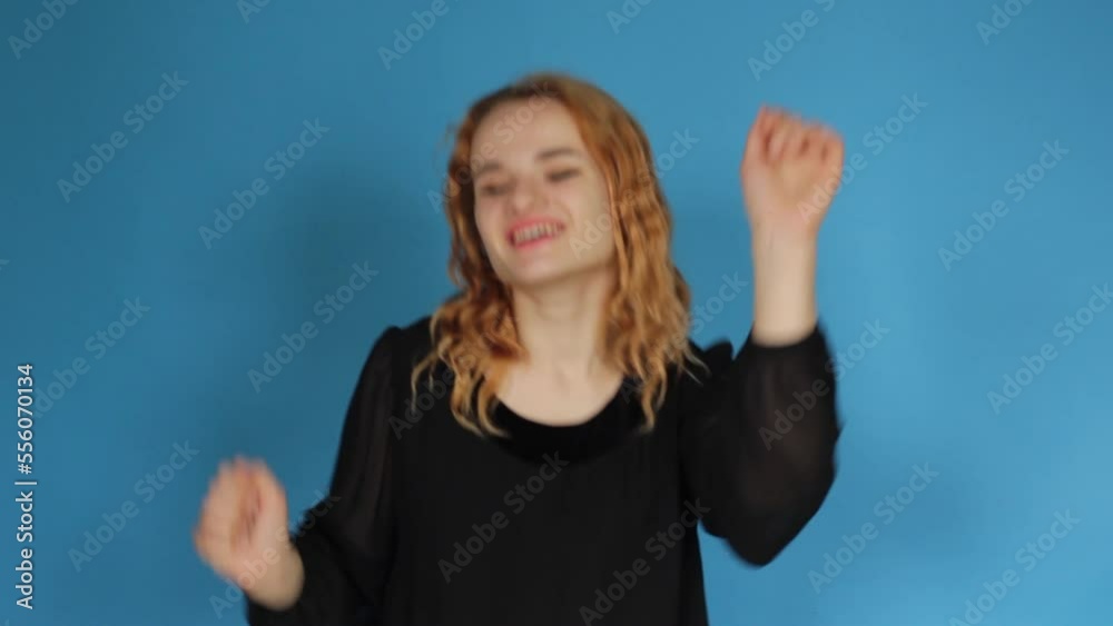 a girl with red hair dancing on a blue background a girl with red hair dancing on a blue background