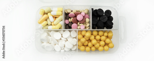 Tablets of different colors in a plastic box. Medical preparations, tablets and capsules and vitamins. pharmaceutical antibiotics. The concept of medicine, healthcare. Pill box.