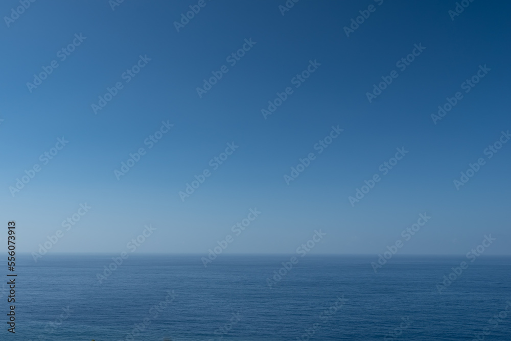 Blue ocean or sea background with blank space. Blue sky above calm water
