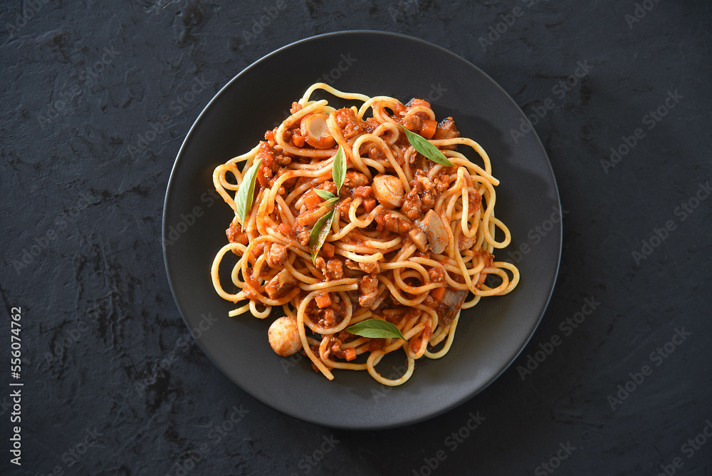 Spaghetti plate on black stone background and space for text.