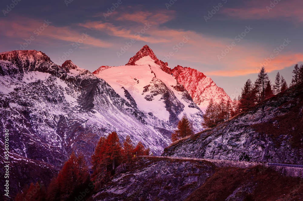 Incredible scenery of European Alps in during sunset. snowy Grossglockner peak glowing in sunlight with perfect colorful sky. Grossglockner High Alpine  is a most popular place of travel.