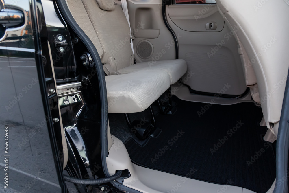 Clean car floor mats of black carpet under rear passenger seat in the workshop for the detailing vehicle before dry cleaning. Auto service industry. Interior of sedan.