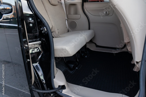 Clean car floor mats of black carpet under rear passenger seat in the workshop for the detailing vehicle before dry cleaning. Auto service industry. Interior of sedan. © Aleksandr Kondratov