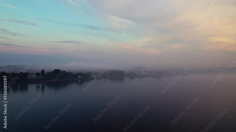 Drone over sea at dusk towards misty coast Drone over sea at dusk towards misty coast