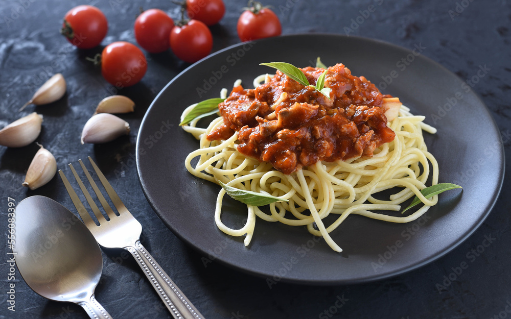 Spaghetti plate on black stone background and space for text.