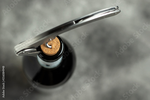 Bottle, corkscrew and cork on a black background. Selective focus. photo