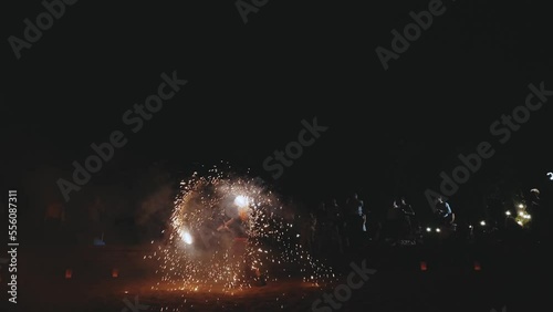 An amazing fire show at night. A woman spinning fire. Back view of female artist performing fireshow. Super slow motion of beautiful fireshow.