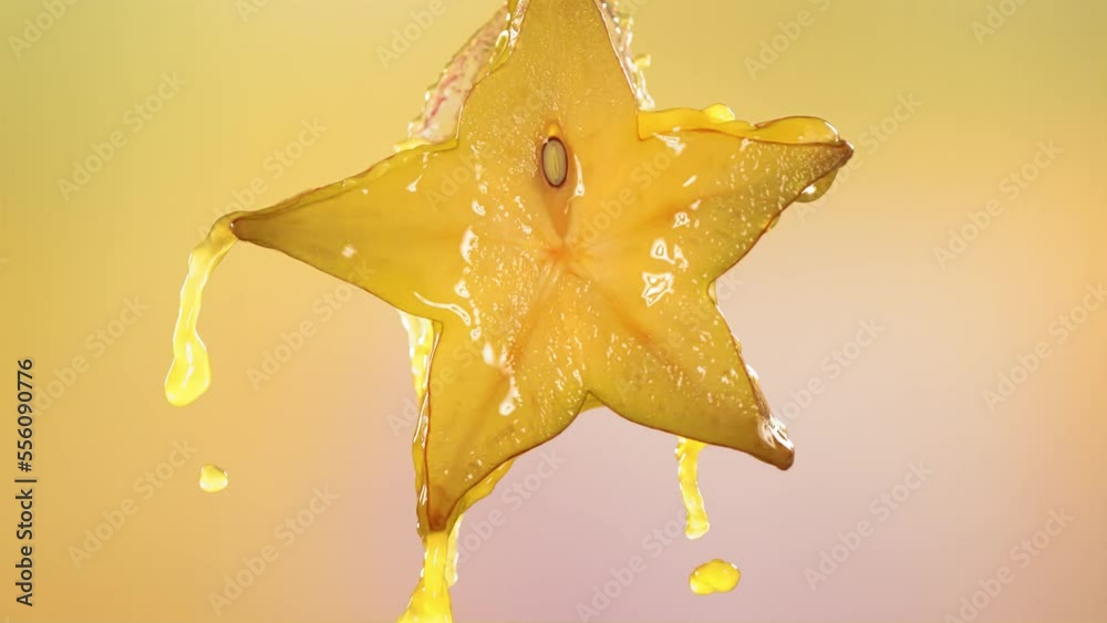 Slow Motion Macro Shot of Flowing Carambola Juice from Halved Carambola