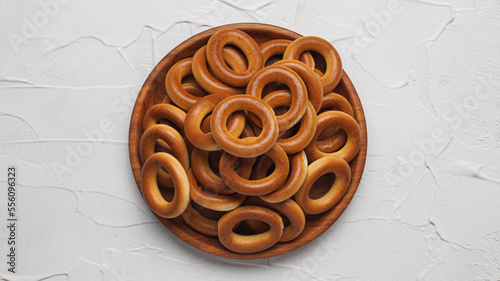 Bowl of tasty dry bagels (sushki) on white textured background, top view photo