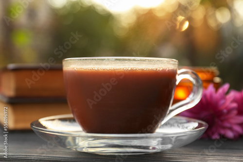 Glass cup with coffee on wooden table, closeup. Morning ritual