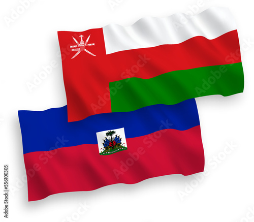 National vector fabric wave flags of Sultanate of Oman and Republic of Haiti isolated on white background. 1 to 2 proportion.