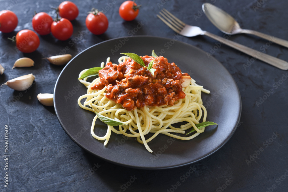 Spaghetti plate on black stone background and space for text.