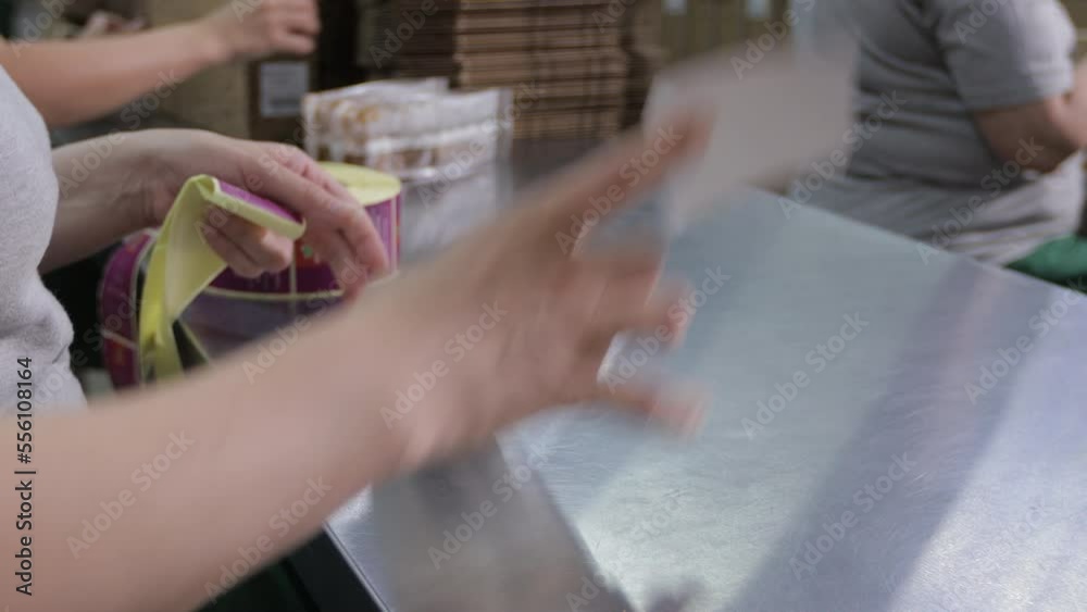 The workers of the tea factory manually glue labels to tea packages.