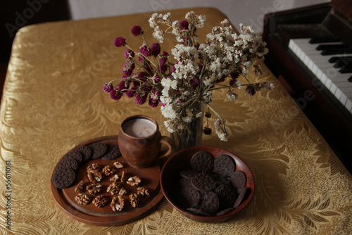 Still life of delicious sweet cookies with milk, flowers and nuts.