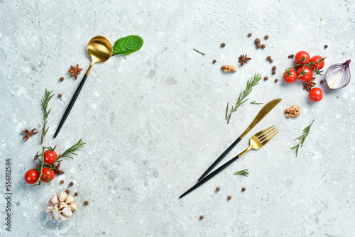 Cooking background: vegetables, spices and kitchen utensils on the table. On a gray stone background. Restaurant menu.