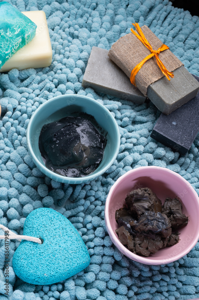 natural  healing  spa set with salt, healing mud and soap on blue bath mat.