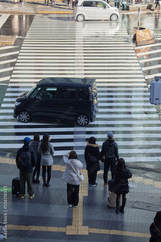 Obraz premium 年末の街の交差点の横断歩道で歩く人々の姿