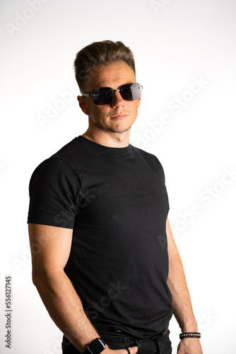 Portrait of cool young guy in black tshirt and sunglasses isolated against a white background