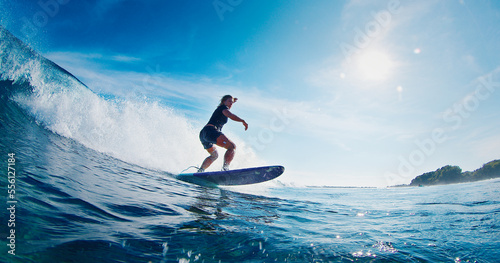 Woman surfer rides the ocean wave in the Maldives