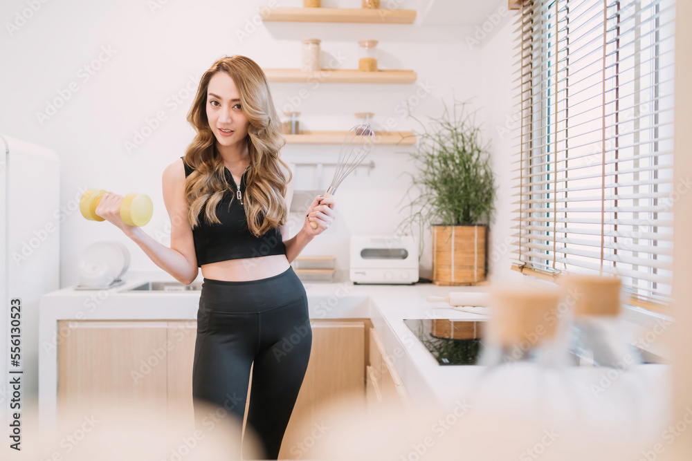 happy woman holding cooking exercising tool in kitchen. beautiful girl suggest people eating smart food and exercising for healthy lifestyle concept. woman control diet and workout training for body happy woman holding cooking exercising tool in kitchen. beautiful girl suggest people eating smart food and exercising for healthy lifestyle concept. woman control diet and workout training for body