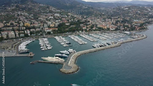 Aerial view of Sanremo, Italian city on the seashore in Liguria, north Italy. Drone flying along the port over beaches and boardwalk with palm trees and Birds Eye of yacht parking in San Remo, Italy. photo